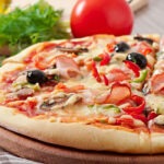 Fritti Di Mare pizza topped with crispy fried seafood including shrimp, calamari, and mussels, with mozzarella cheese and a tomato-based sauce on a thin pizza crust.